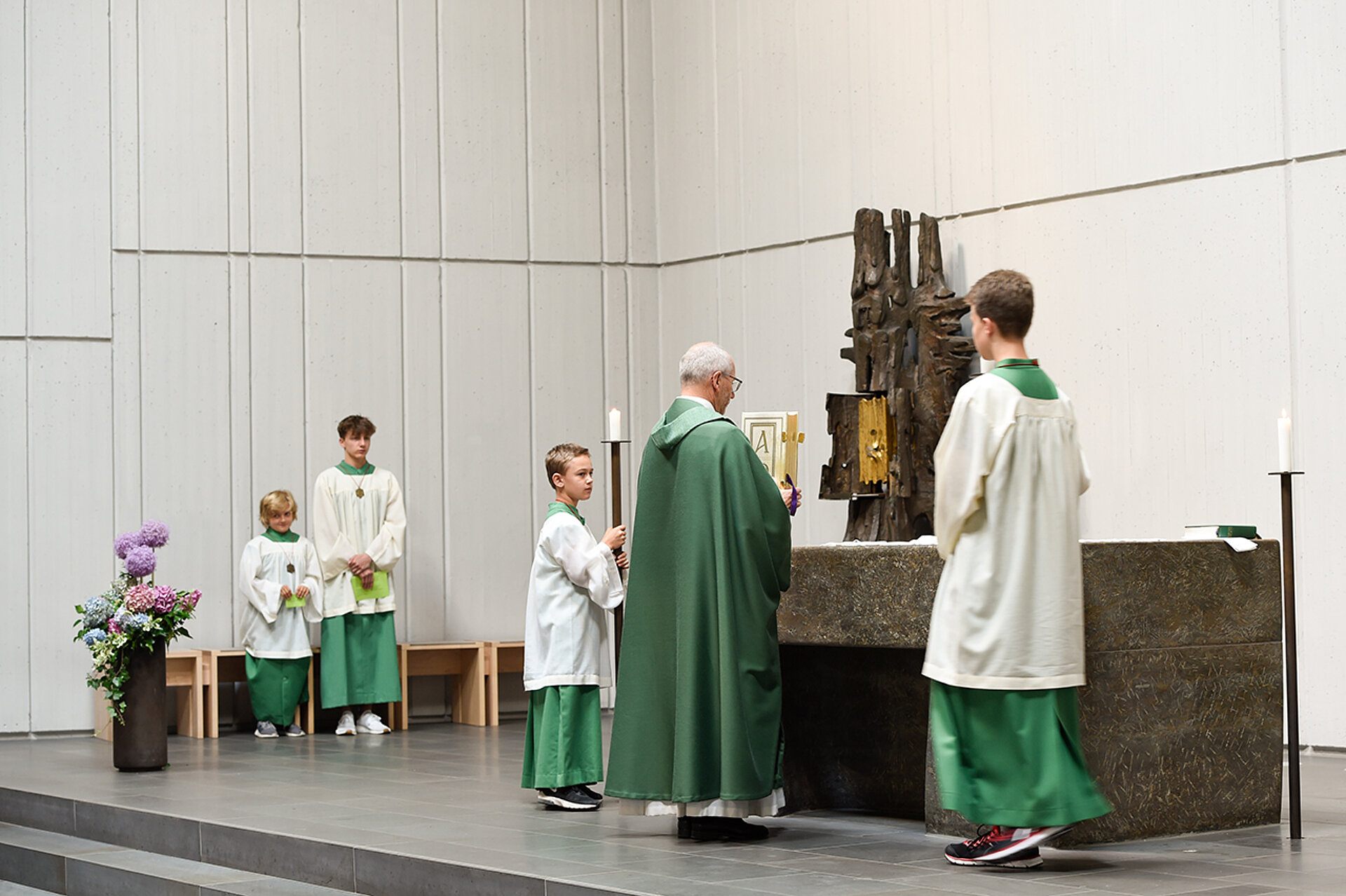 Ministranten und Pfarrer bereiten die Gaben